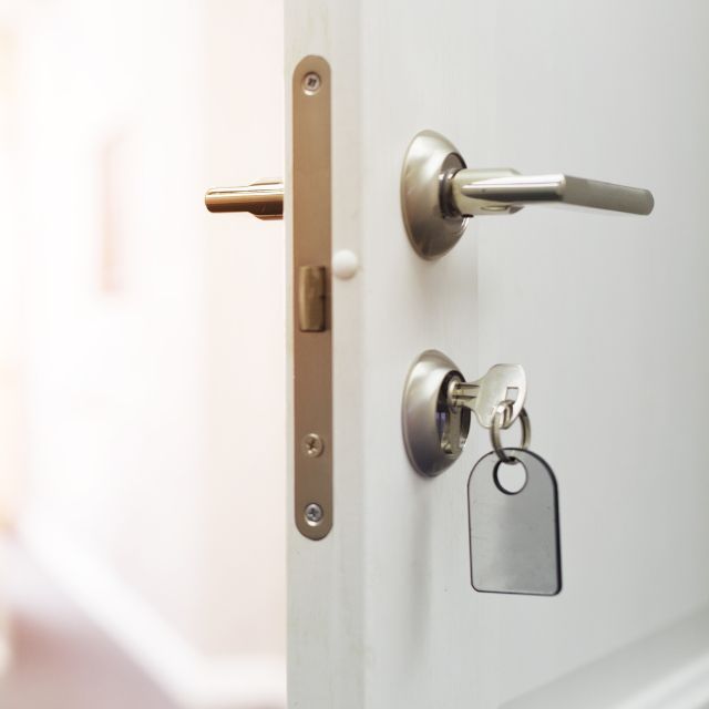Hausttür offen mit einem Türgriff und Schlüssel 